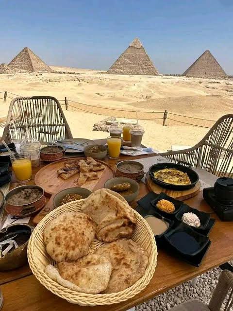 Flatbread and dips on a table in front of the pyramids of Giza